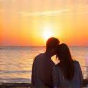 Couple relaxing on a beach at sunset